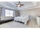Comfortable main bedroom featuring a tray ceiling, ceiling fan, and natural lighting at 4541 Old Highway 138 Sw, Loganville, GA 30052
