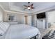 Spacious main bedroom featuring a tray ceiling, ceiling fan, TV, and an en-suite bathroom at 4541 Old Highway 138 Sw, Loganville, GA 30052