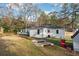 Backyard view featuring a deck, home exterior, shed, and grassy yard at 1751 Nathan Ln, Austell, GA 30168