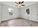Bedroom with hardwood floors, two windows, and a modern ceiling fan at 1751 Nathan Ln, Austell, GA 30168