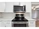 Close-up of stainless steel stove and white cabinets in updated kitchen at 1751 Nathan Ln, Austell, GA 30168
