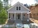 Charming craftsman-style home featuring a welcoming front porch with elegant white columns and a gabled roofline at 11792 Serenbe Ln, Chattahoochee Hills, GA 30268
