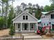 Charming craftsman-style home featuring a welcoming front porch, brick chimney, and professionally landscaped yard at 11792 Serenbe Ln, Chattahoochee Hills, GA 30268