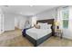 Spacious primary bedroom featuring a large bed, neutral decor, and a view into the ensuite bathroom at 819 Major Oak Ct, Villa Rica, GA 30180