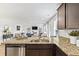 Open-concept kitchen with granite counters and a view of the living area with a cozy fireplace at 819 Major Oak Ct, Villa Rica, GA 30180
