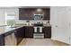 Galley kitchen featuring stainless steel appliances, granite countertops, and dark wood cabinets at 819 Major Oak Ct, Villa Rica, GA 30180