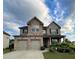 Two-story brick home with three-car garage and landscaped yard at 2239 Noelle Pl, Powder Springs, GA 30127