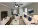 Bright living room with hardwood floors, comfy seating, and large TV at 721 Yale Sw Pl, Atlanta, GA 30315