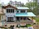 New home construction featuring a stone foundation, red-framed windows, and a partially completed roof at 11798 Serenbe Ln, Chattahoochee Hills, GA 30268