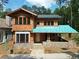 Under construction two-story home with cedar shake siding, stone accents, covered porch, and forest backdrop at 11798 Serenbe Ln, Chattahoochee Hills, GA 30268