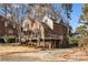 Brick home with a large deck and driveway, surrounded by mature trees at 1136 Goodwin Ne Rd, Atlanta, GA 30324