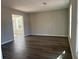 Spacious living room with dark wood floors and neutral walls at 627 Huntington Nw Way, Lilburn, GA 30047