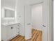 Contemporary bathroom vanity with storage and backlit mirror plus the entrance to a walk-in closet at 2208 Baker Nw Rd, Atlanta, GA 30318