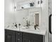 Modern bathroom with dual sinks, marble countertops, black fixtures, and decorative accessories at 2208 Baker Nw Rd, Atlanta, GA 30318