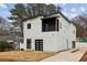Beautiful two-story home with a modern exterior, black trim, balcony, and a concrete driveway at 2208 Baker Nw Rd, Atlanta, GA 30318