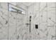 Close up of the elegant shower with marble-patterned walls, rainfall showerhead, and built-in niche at 2208 Baker Nw Rd, Atlanta, GA 30318