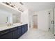 Elegant bathroom with double vanity, marble floors, and a glass-enclosed shower with a tub at 688 Calvet Way, Cumming, GA 30041