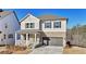 Charming two-story home with grey siding, brick accents, a covered porch, and a two-car garage at 688 Calvet Way, Cumming, GA 30041