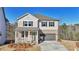 Charming two-story home with brick accents, a covered porch, and a two-car garage, set against a backdrop of trees at 688 Calvet Way, Cumming, GA 30041