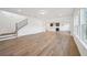 Open-concept living space with hardwood floors connecting to the kitchen and featuring staircase and large windows at 688 Calvet Way, Cumming, GA 30041
