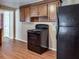 Kitchen with wood cabinets, black appliances, and laminate flooring at 4395 Fence Rd, Auburn, GA 30011