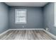 Simple bedroom with grey walls, wood-look flooring, and a window with blinds at 4598 Flint Hill Rd, Austell, GA 30106