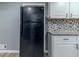 Black refrigerator in renovated kitchen with hexagon tile backsplash at 4598 Flint Hill Rd, Austell, GA 30106