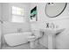 Elegant bathroom with a classic white pedestal sink, bathtub, and patterned floor at 796 Palatine Se Ave, Atlanta, GA 30316