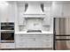 Modern kitchen with gray cabinets, a white range hood, and quartz countertops at 3033 Hosch Retreat Park, Buford, GA 30519