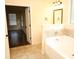 Bright bathroom with marble countertop, bathtub, and elegant vanity lights with a door to bedroom at 7940 White Oak Loop, Lithonia, GA 30038