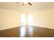 Bright bedroom with ceiling fan, hardwood floors, and natural light from two windows at 7940 White Oak Loop, Lithonia, GA 30038