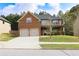 Charming two-story home features a brick facade, two-car garage, and a well-manicured lawn at 7940 White Oak Loop, Lithonia, GA 30038