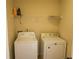 Functional laundry room featuring washer, dryer, and wire shelf maximizing space at 7940 White Oak Loop, Lithonia, GA 30038