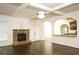 Open-concept living room with a fireplace, hardwood floors, an archway, and a glimpse of the kitchen at 7940 White Oak Loop, Lithonia, GA 30038