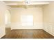 A bright living room features tray ceilings, wainscoting, hardwood floors, and a large window at 7940 White Oak Loop, Lithonia, GA 30038