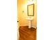 Powder room features pedestal sink, wood-look flooring, and modern fixtures at 7940 White Oak Loop, Lithonia, GA 30038