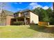 This home offers great curb appeal with a well-kept lawn, brick accents, and a wooden fence at 7940 White Oak Loop, Lithonia, GA 30038