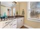 Elegant bathroom with granite countertop, white cabinets, and large window at 192 Chicopee Ne Dr, Marietta, GA 30060