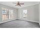 Bright bedroom with two windows, ceiling fan, and grey carpeting at 3404 Mount Olive Rd, Atlanta, GA 30344