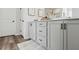 This bathroom has wood look flooring, white stone countertop, and ample storage in the gray vanity at 316 Rodeo Dr, Auburn, GA 30011