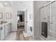 A bright bathroom features a double vanity, glass shower, soaking tub, and doorway access to the main bedroom at 316 Rodeo Dr, Auburn, GA 30011