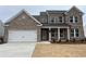 Charming two-story brick home with a two-car garage and a covered front entry at 714 Ocmulgee Xing, Locust Grove, GA 30248