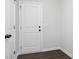 Hallway area featuring a white door and trim, complemented by modern, dark wood-look flooring for a clean and stylish look at 714 Ocmulgee Xing, Locust Grove, GA 30248