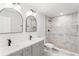 Bathroom featuring dual sinks, marble countertops, decorative mirrors, and a walk-in shower at 860 Gardner Sw St, Austell, GA 30168
