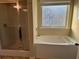 Bathroom featuring a soaking tub, separate shower, and frosted window at 3885 Nixon Grove Dr, Douglasville, GA 30135