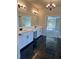 Bright bathroom boasts double vanity and black marble floors at 4010 Sierra Vista Cir, Cumming, GA 30040