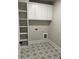 Laundry room with white cabinets, shelving, and star patterned tile floor at 4010 Sierra Vista Cir, Cumming, GA 30040