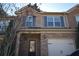 Brick front elevation of a two-story townhome with a two-car garage at 7765 Haynes Park Cir, Lithonia, GA 30038