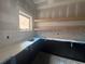 Unfinished butler's pantry features light countertops, a sink, tile backsplash, and floating shelves at 839 Braselton Hwy, Lawrenceville, GA 30043