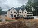 Spacious new construction home featuring light brick facade, modern design, and construction equipment at 839 Braselton Hwy, Lawrenceville, GA 30043